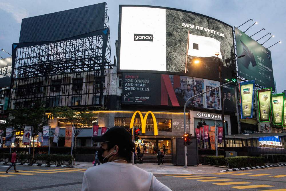 A digital screen displays a white flag campaign in Bukit Bintang, Kuala Lumpur July 9, 2021. u00e2u20acu201d Picture by Firdaus Latif