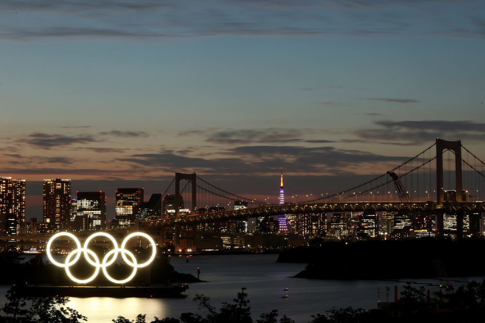 A general view of the Olympic Rings installed on a floating platform with the Rainbow Bridge in the background in preparation for the Tokyo 2020 Olympic Games in Tokyo, Japan June 21, 2021. u00e2u20acu201d Reuters picnn