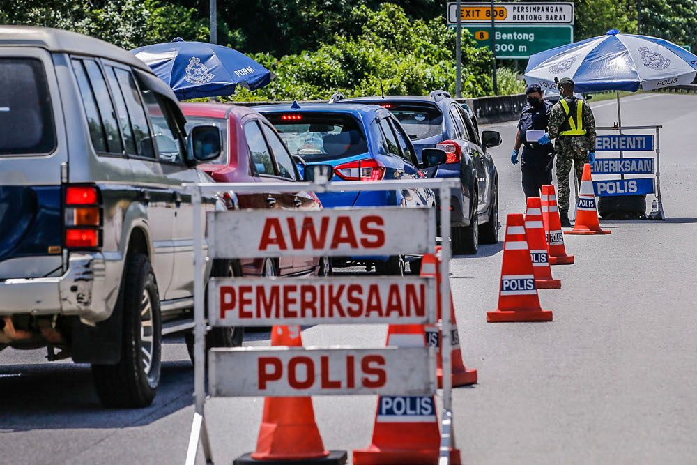 Members of the Royal Malaysian Police (PDRM) together with the Armed Forces (ATM) checking vehicles wishing to enter the East Coast exit at the Bentong Toll Plaza July 19, 2020. u00e2u20acu201d Picture by Hari Anggara