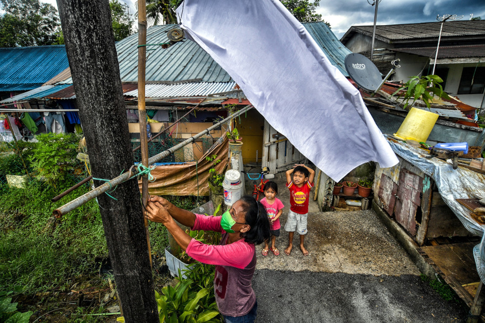 Noni Umpik ties a white flag at her rented home in Jalan Foochow, Kuching, June 30, 2021. u00e2u20acu201d Bernama pic 