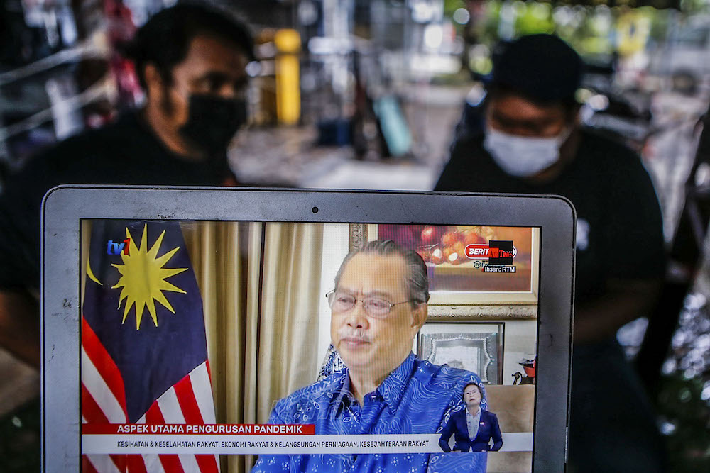 People watch the live telecast of Prime Minister Tan Sri Muhyiddin Yassin giving his special announcement, August 8, 2021. u00e2u20acu2022 Picture by Hari Anggara