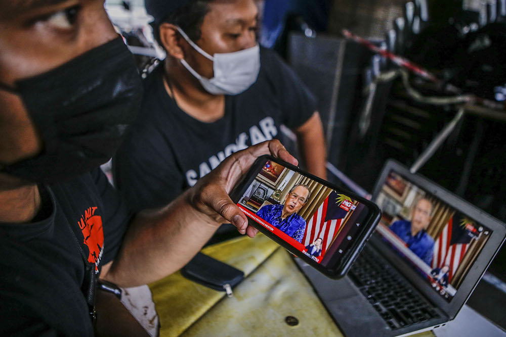 People watch the live telecast of Prime Minister Tan Sri Muhyiddin Yassin giving his special announcement, August 8, 2021. u00e2u20acu2022 Picture by Hari Anggara