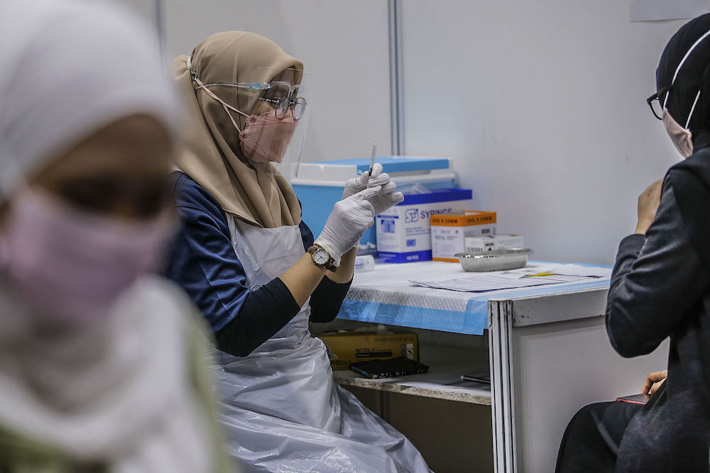 A health worker prepares the Covid-19 vaccination at the vaccination centre (PPV) in Kuala Lumpur Convention Center August 8, 2021. u00e2u20acu2022 Picture by Hari Anggara