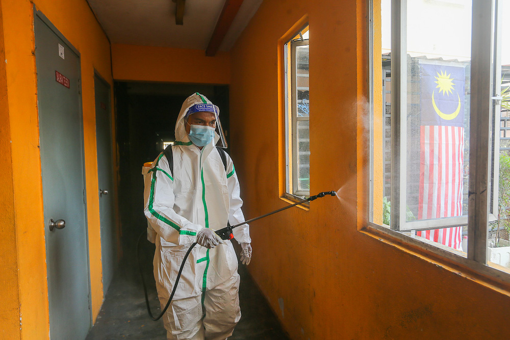 A firefighter sprays disinfectant at Pangsapuri Subang Suria amid the Covid-19 outbreak in Shah Alam August 15, 2021. u00e2u20acu201d Picture by Yusof Mat Isa