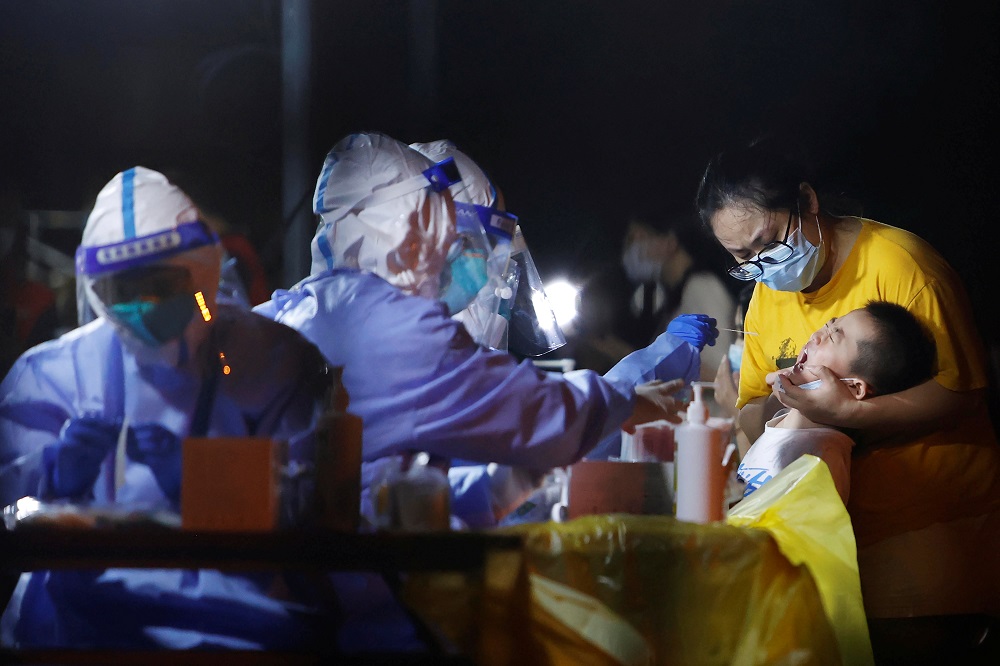 A medical worker in protective suit conducts a swab test following a new case of Covid-19 in Shanghai, China August 2, 2021. Picture taken August 2, 2021. u00e2u20acu2022 cnsphoto via Reuters