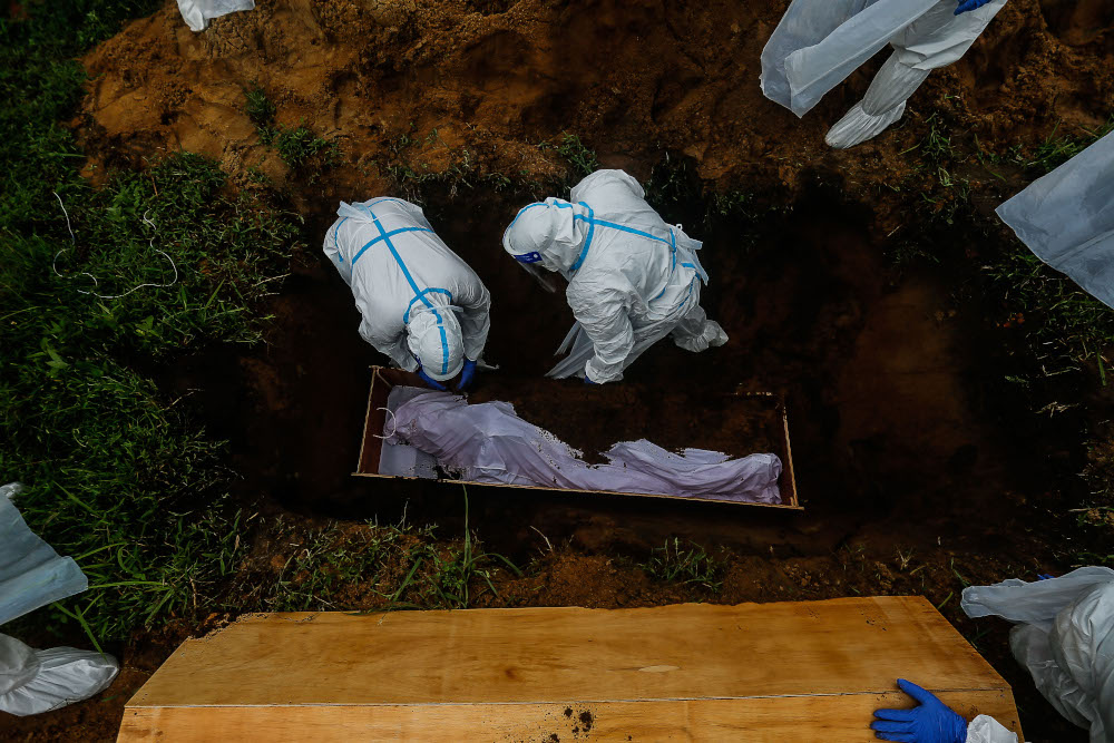 Volunteers prepare the body of a Covid-19 victim for burial at Bagan Ajam Muslim Cemetery, August 24, 2021. u00e2u20acu201d Picture by Sayuti Zainudin