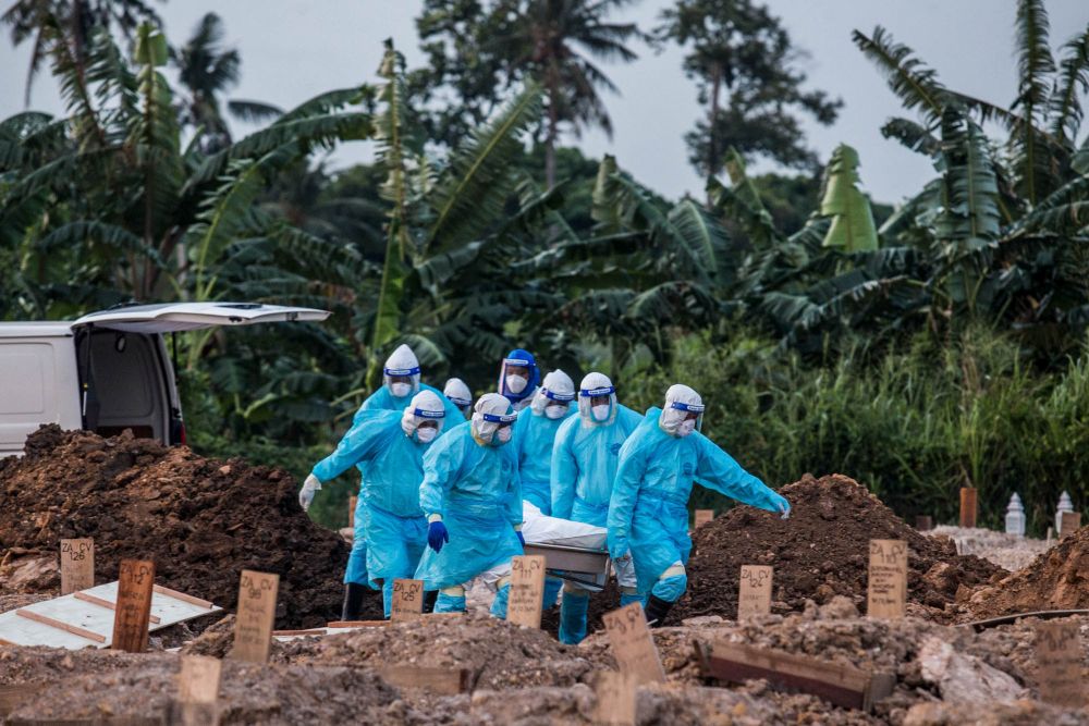 Funeral workers wearing protective suits bury the remains of a Covid-19 victim at a cemetery in Klang August 7, 2021. u00e2u20acu201d Picture by Firdaus Latifnn