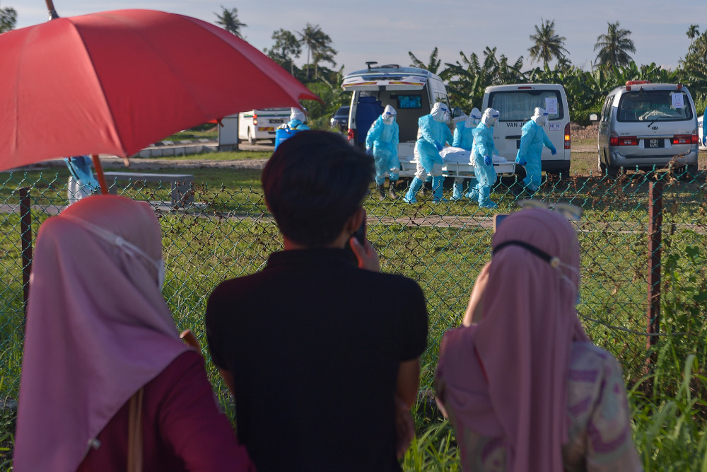 Family members of Covid 19 victims were only able to see the funeral of their loved one from outside the fence at the Islamic cemetery in Klang August 6, 2021. u00e2u20acu2022 Picture by Miera Zulyana