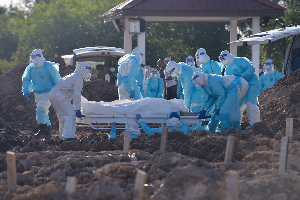 Health personnel bury the body of a Covid-19 victim at the Islamic cemetery in Klang August 6, 2021. u00e2u20acu2022 Picture by Miera Zulyana