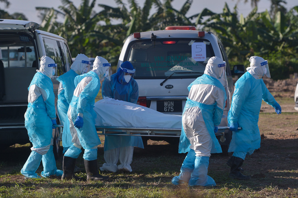 Health personnel bury the body of a Covid-19 victim at the Islamic cemetery in Klang August 6, 2021. u00e2u20acu2022 Picture by Miera Zulyana