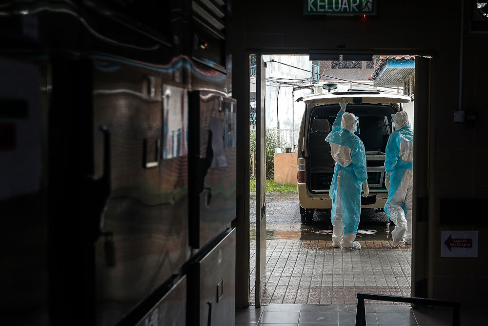 The forensics team prepares to transport the body of a recently deceased Covid-19 patient to a burial site from the Penang General Hospital, August 24, 2021. u00e2u20acu201d Picture by Sayuti Zainudin