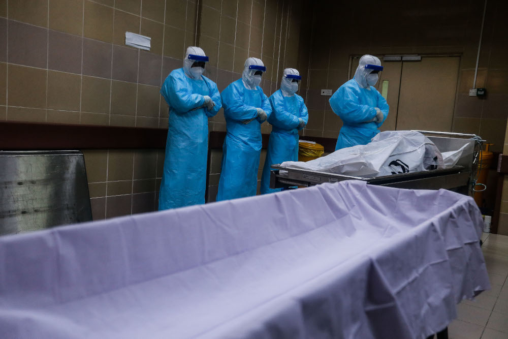 Forensic personnel conduct prayers for a recently deceased Covid-19 patient as they prepare the body for burial at the Penang General Hospital, August 24, 2021. u00e2u20acu201d Picture by Sayuti Zainudin