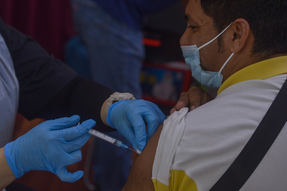 A foreign worker receives his Covid-19 vaccination at Komplek Sukan PKNS in Kelana Jaya August 10, 2021. u00e2u20acu201d Picture by Miera Zulyana