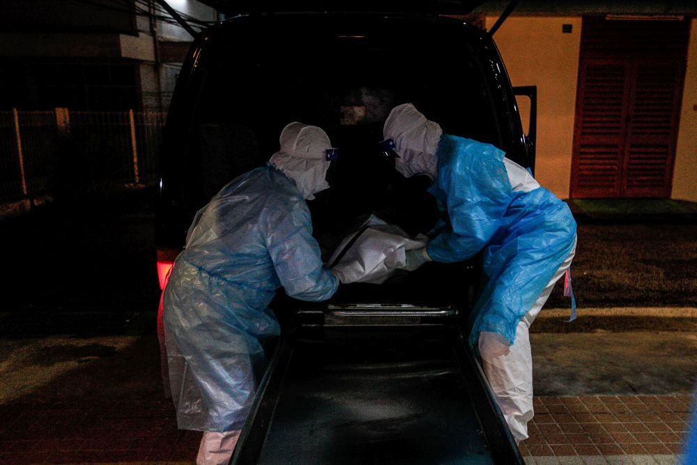 Forensics personnel unload the body of a recently deceased Covid-19 patient at the Penang General Hospital, August 24, 2021. u00e2u20acu201d Picture by Sayuti Zainudin