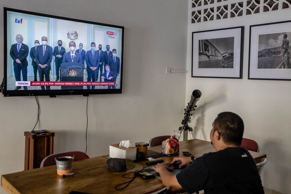 A man watches a live telecast of Prime Minister Tan Sri Muhyiddin Yassin's speech in Kuala Lumpur August 4, 2021. u00e2u20acu201d Picture by Firdaus Latif
