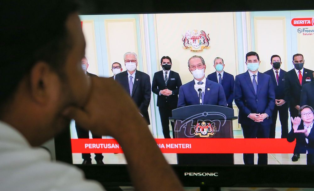 A man watches a live telecast of Prime Minister Tan Sri Muhyiddin Yassinu00e2u20acu2122s speech in Ipoh August 4, 2021. u00e2u20acu201d Picture by Farhan Najib