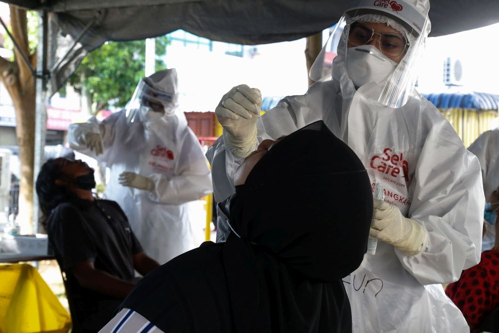 Healthcare workers collect swab samples to test for Covid-19 during a mass screening exercise in Taman Manggis, George Town August 12, 2021. u00e2u20acu201d Picture by Sayuti Zainudin