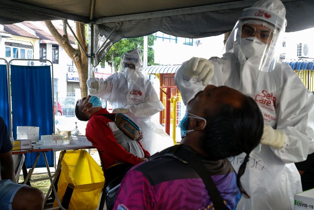 Healthcare workers collect swab samples to test for Covid-19 during a mass screening exercise in Taman Manggis, George Town August 12, 2021. u00e2u20acu201d Picture by Sayuti Zainudin