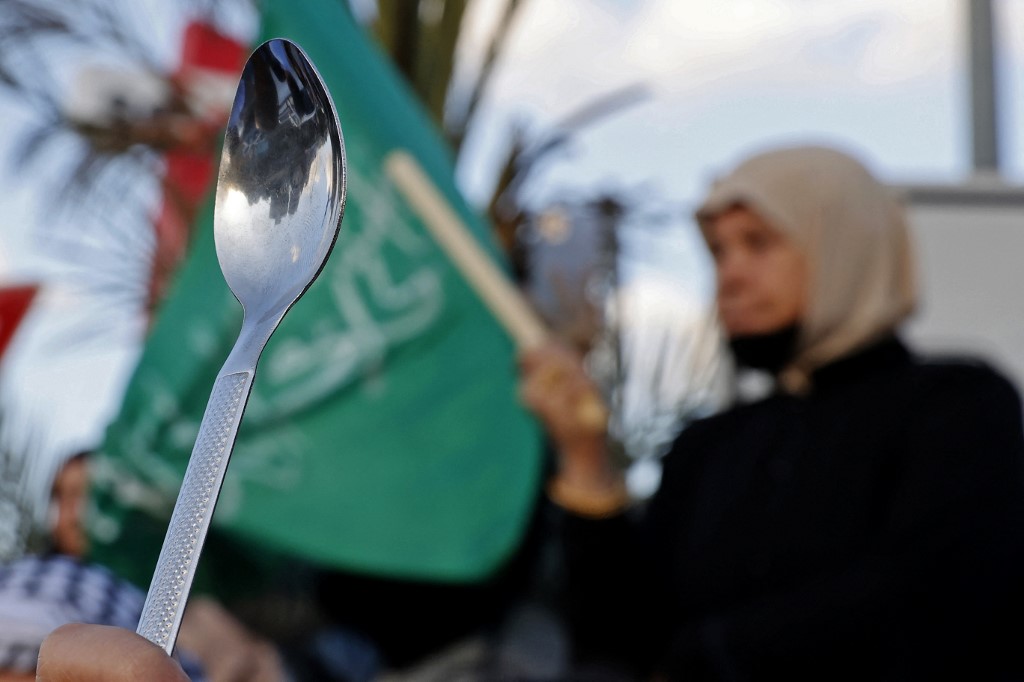 Arab-Israeli protesters lift spoons, reportedly the digging tool used by six Palestinian prisoners who escaped from Israel's Gilboa prison, as they demonstrate in the mostly Arab city of Umm al-Fahm in northern Israel, on September 10, 2021. (JACK GUEZ / 