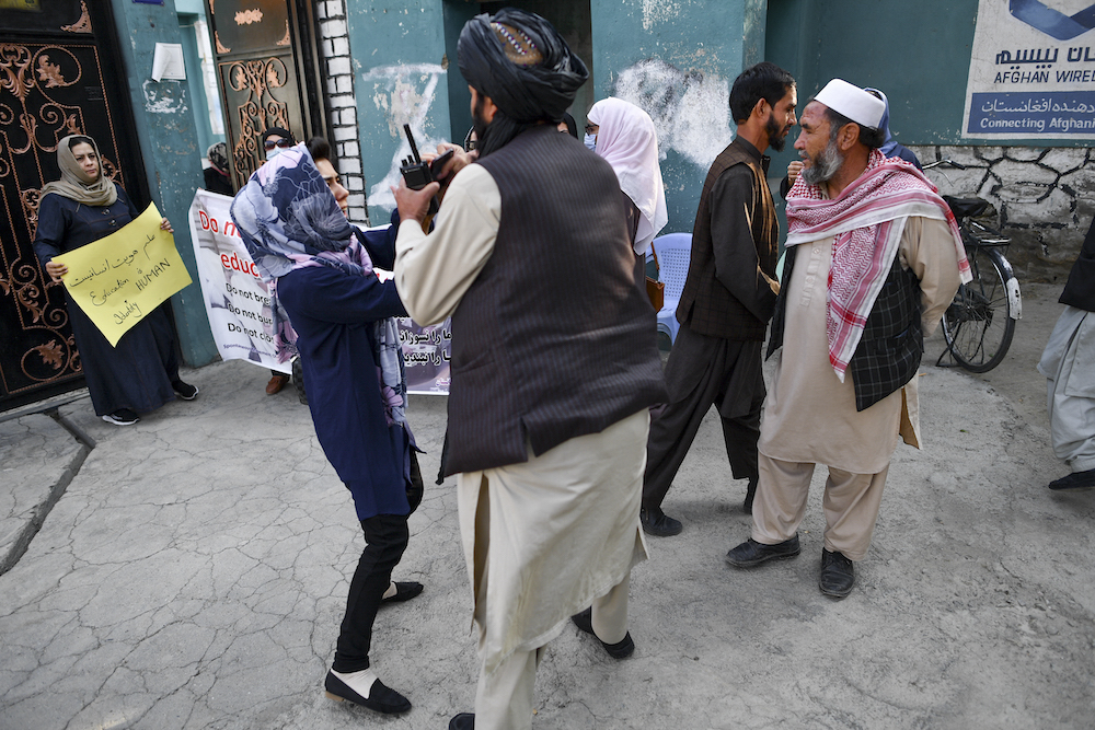 A woman protestor scuffles with a member of the Taliban during a demonstration outside a school in Kabul September 30, 2021. u00e2u20acu201d AFP pic