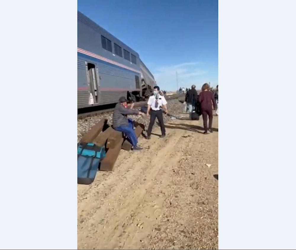 People wait at the side of train tracks at the scene of a train derailment near Havre, Montana, US, September 25, 2021, in this still image obtained from video. u00e2u20acu201d Courtesy of Jacob Cordeiro / Social Media via Reuters