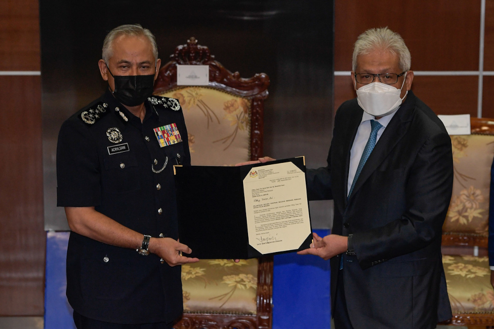 Home Minister Datuk Seri Hamzah Zainudin hands over the letter of appointment to Datuk Seri Acryl Sani Abdullah Sani at Bukit Aman, September 29, 2021. u00e2u20acu201d Bernama pic 