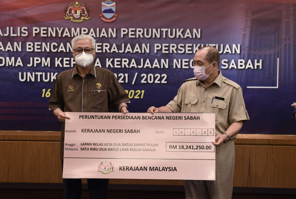 Prime Minister Datuk Seri Ismail Sabri Yaakob (left) hands over a mock cheque to Sabah Chief Minister Datuk Hajiji Noor in Kota Kinabalu September 16, 2021. u00e2u20acu2022 Bernama picnn