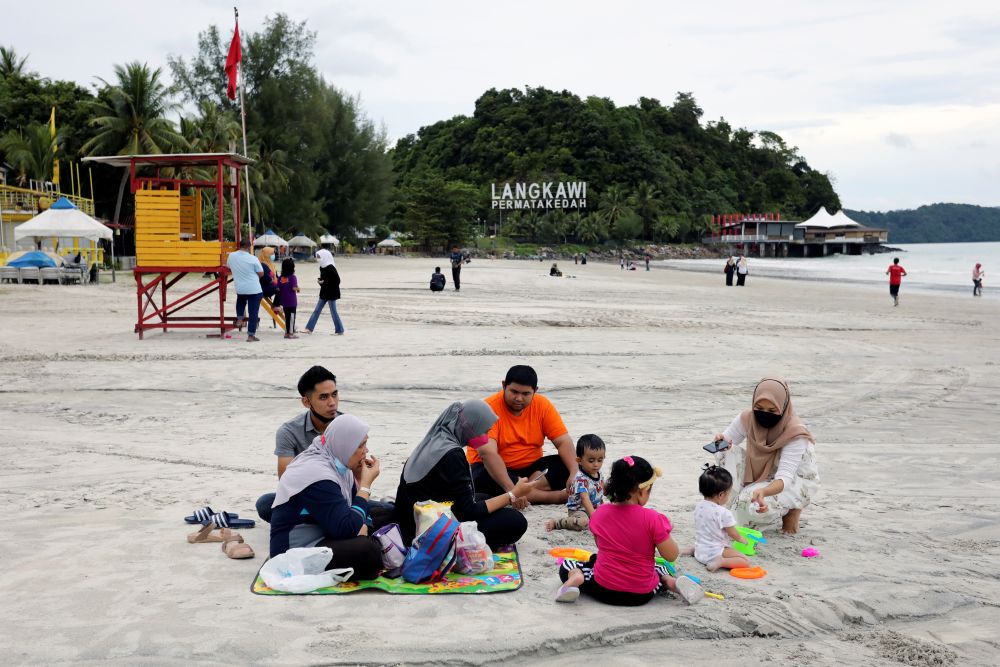 People enjoy a picnic at Cenang Beach as Langkawi gets ready to open to domestic tourists from September 16, 2021. u00e2u20acu201d Reuters pic