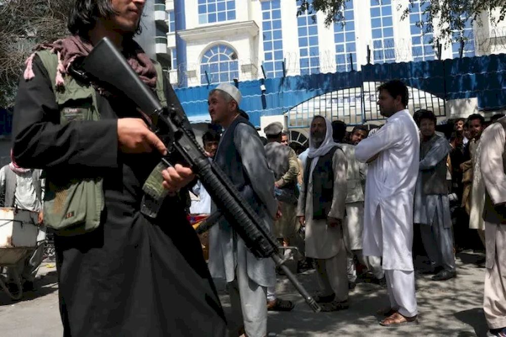A Taliban security member holding a rifle ensures order in front of Azizi Bank in Kabul. u00e2u20acu201d Reuters pic