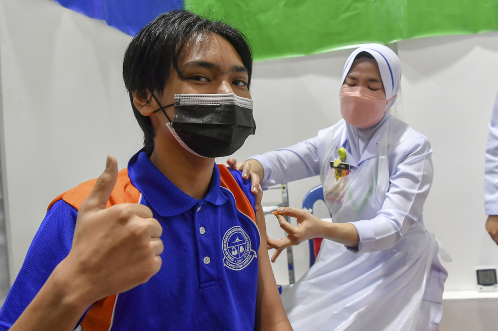Student Zahin Erfan Mohd Yusri gives the thumbs up sign while receiving the Covid-19 vaccination at Sekolah Menengah Kebangsaan (SMK) Putrajaya Precinct 8, September 20, 2021. u00e2u20acu201d Bernama pic 