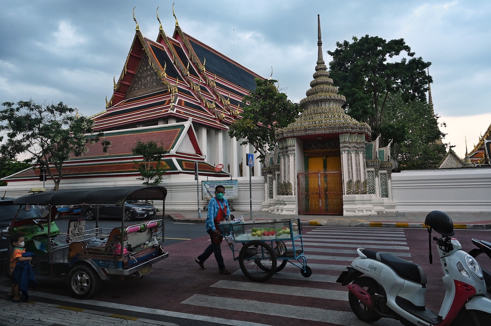 This photo taken on October 25, 2021 shows a fruit vendor behind Wat Pho Buddhist temple, a popular tourist spot near the Grand Palace, in Bangkok. u00e2u20acu201d AFP pic