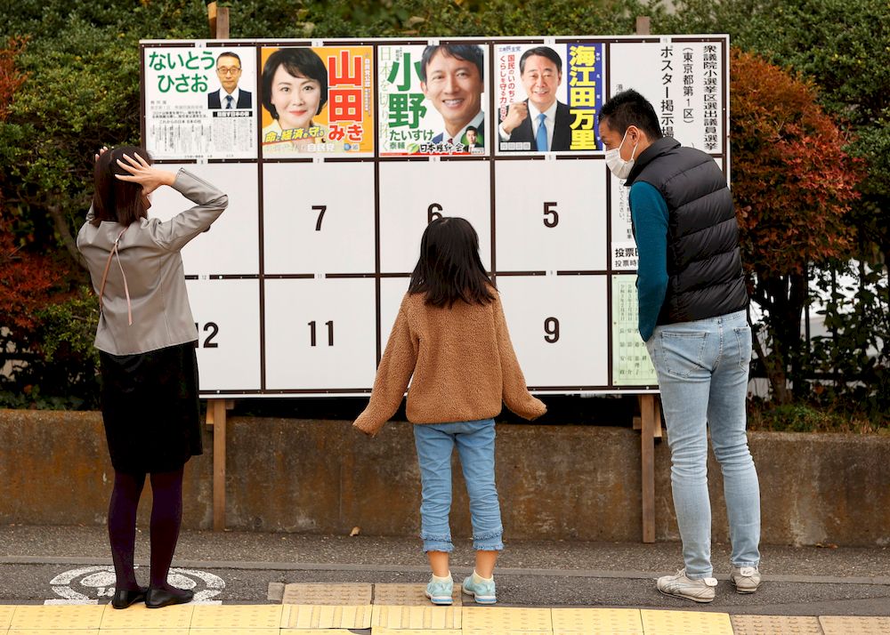 Voters look at posters of candidates for a lower house election, amid the coronavirus disease (Covid-19) pandemic, outside a polling station in Tokyo, Japan October 31, 2021. u00e2u20acu201d Reuters pic