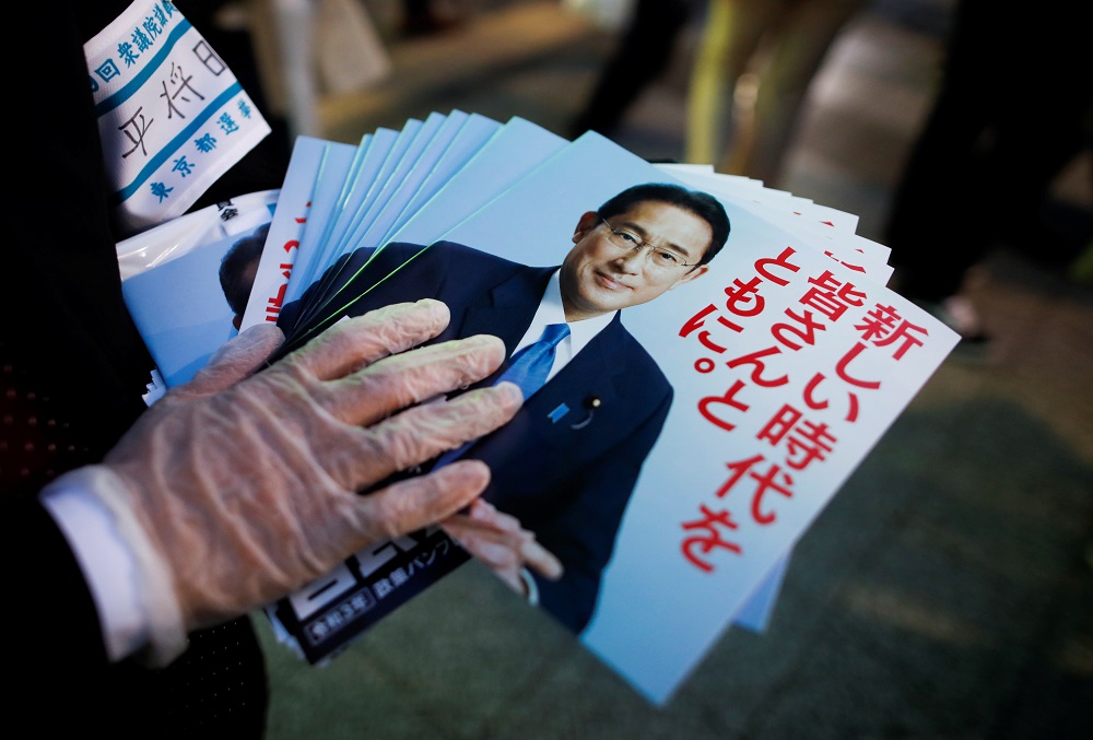 An election campaign staff member holds leaflets of Japan's ruling Liberal Democratic Party with cover photos of Japan's Prime Minister and the party's president Fumio Kishida in Tokyo, Japan October 19, 2021. u00e2u20acu2022 Reuters pic