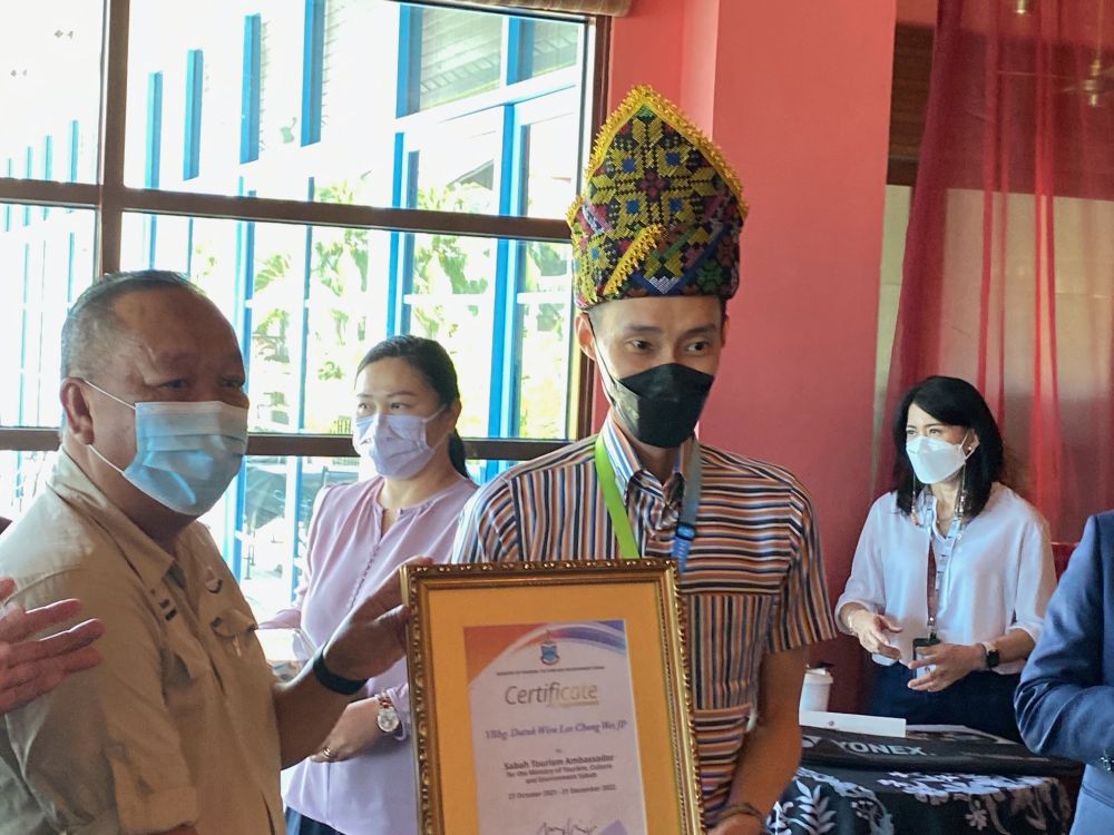 Datuk Lee Chong Wei (right) bearing the Siga, a traditional Kadazandusun headdress, presented by Datuk Jafry Arifin. u00e2u20acu201d Picture by Julia Chan