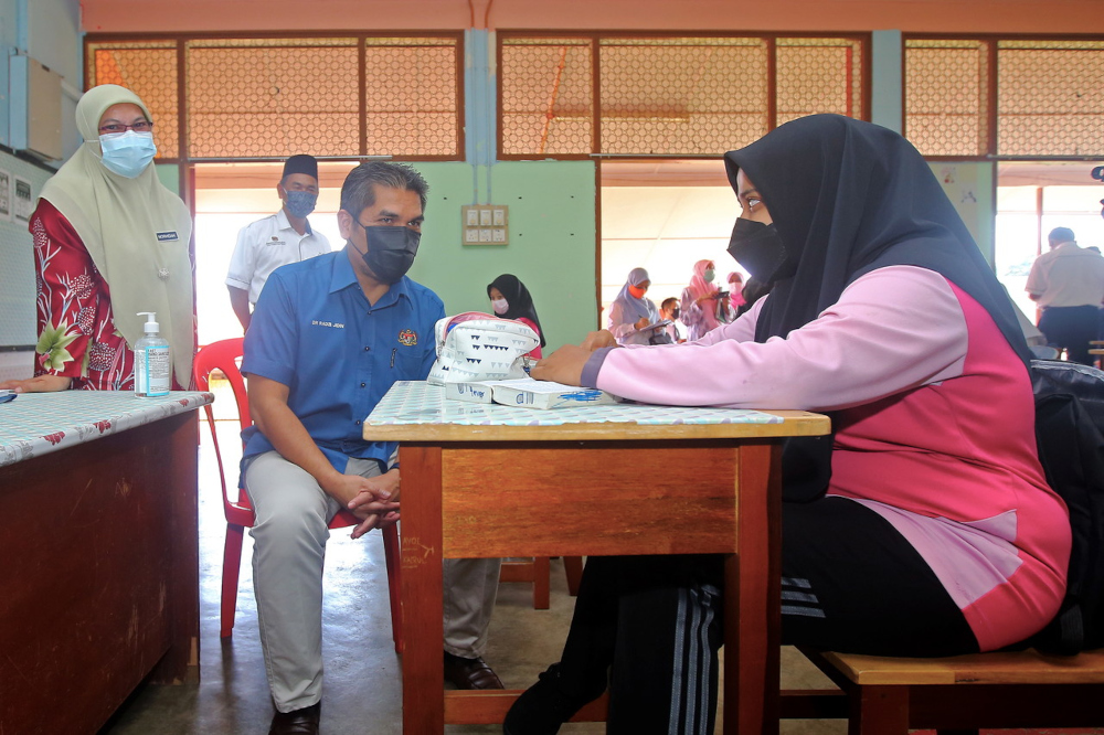 Senior Education Minister Datuk Mohd Radzi Md Jidin speaks to a student during a visit to Sekolah Menengah Kebangsaan (SMK) Tunku Khurshiah in Kuala Pilah, October 4, 2021. u00e2u20acu201d Bernama pic