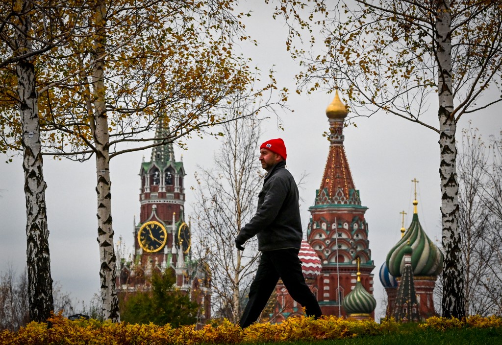 A man walks in the Zaryadye park near the Spasskaya tower of the Kremlin (left) and the Saint Basilu00e2u20acu2122s cathedral (right) in Moscow on October 27, 2021. u00e2u20acu201d AFP pic