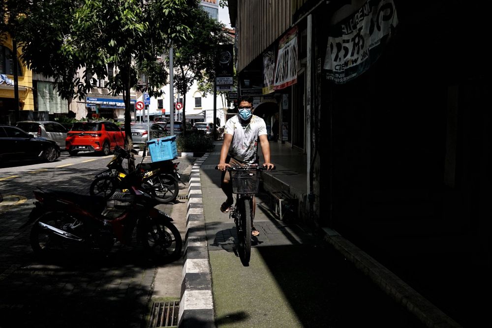 A man riding a bicycle is pictured wearing a protective mask in Kuala Lumpur November 28, 2021. u00e2u20acu201d Picture by Ahmad Zamzahuri
