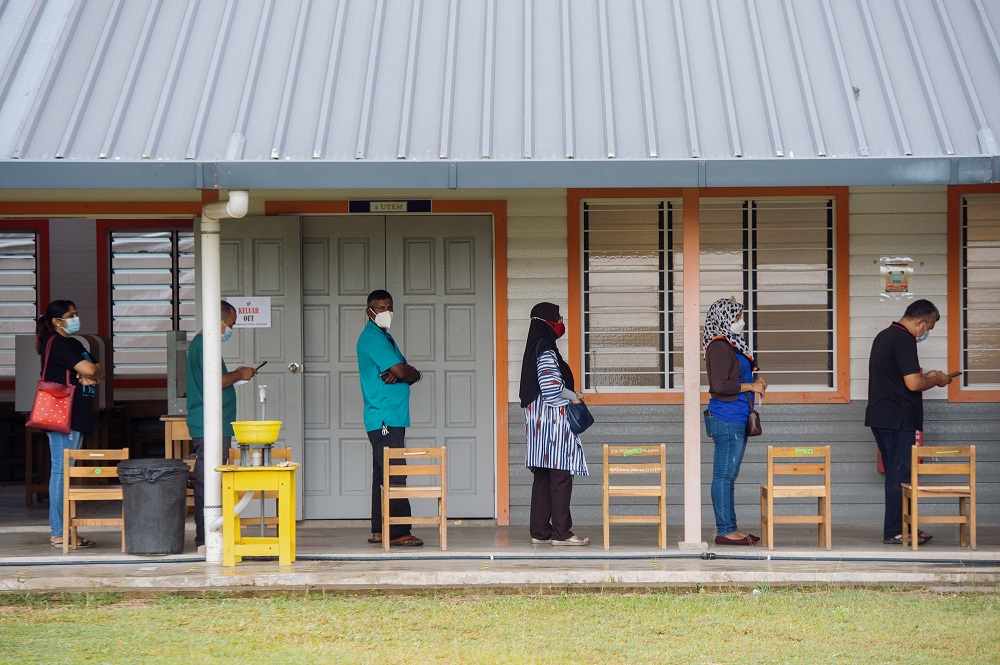 Voters wearing protective masks queue up to cast their votes at the SK Durian Tunggal polling station during the Melaka state election on November 20, 2021. u00e2u20acu2022 Picture by Shafwan Zaidon