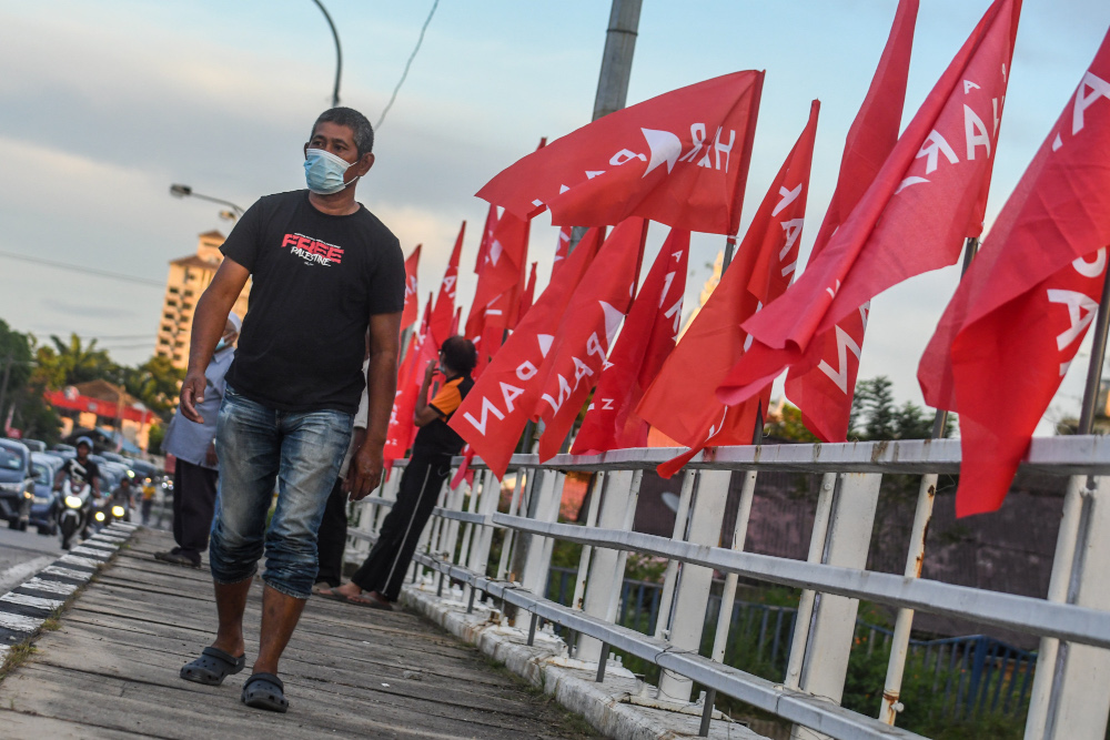 A Pakatan Harapan volunteer putting up PH flags at Jalan Klebang for the Melaka election, November 8, 2021. u00e2u20acu201d Picture by Shafwan Zaidon