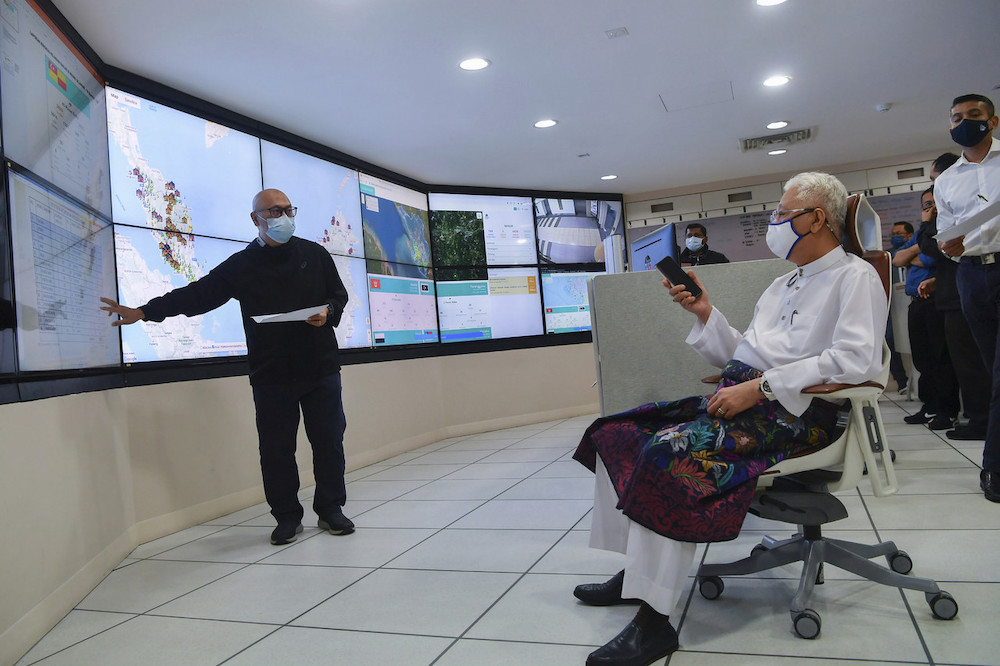 Prime Minister Datuk Seri Ismail Sabri Yaakob being briefed on the countryu00e2u20acu2122s flood situation by Nadma director-general Datuk Aminuddin Hassim at the National Disaster Control Centre in Puchong December 18, 2021. u00e2u20acu201d Bernama pic