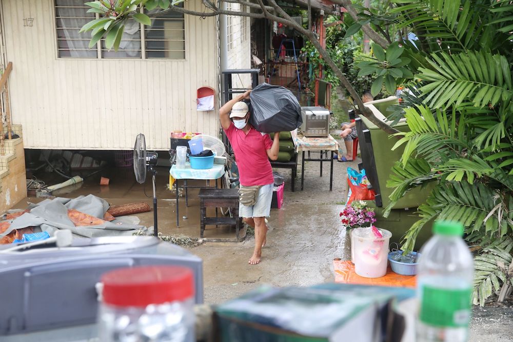 Residents of Kampung Petaling Bahagia in Kuala Lumpur clean up after the area was flooded last night, December 19, 2021. u00e2u20acu201d Picture by Choo Choy May