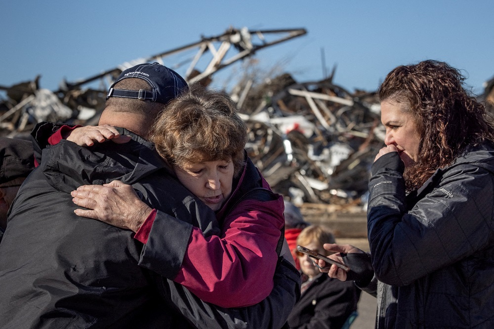 Local residents Darlene Easterwood and Tim Evans embrace after taking part in an outdoor Sunday service with members of First Christian Church and First Presbyterian Church in the aftermath of a tornado in Mayfield, Kentucky December 12, 2021. u00e2u20acu201d Reuters