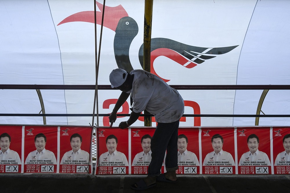 A Gabungan Parti Sarawak supporter puts up party banners ahead of the Sarawak state election in Kuching December 11, 2021. u00e2u20acu201d Bernama pic