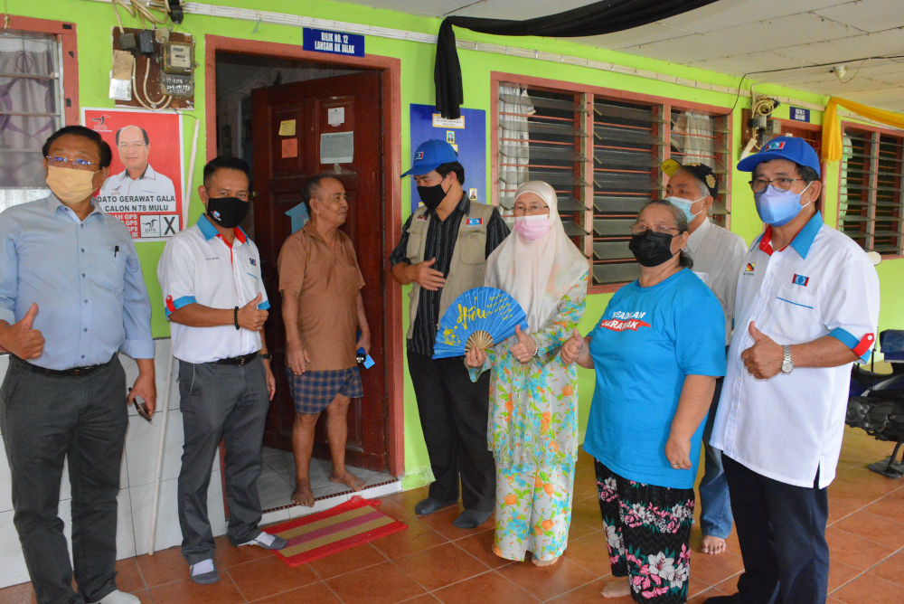 Datuk Seri Dr Wan Azizah (3rd right) in a photo call with one of the voters at Rh Gudang today. She was accompanied by Miri MP Dr Michael Teo Yu Kheng (far left), Elias Lipi 2nd left) and Roland Engan (4th left). u00e2u20acu201d Borneo Post pic