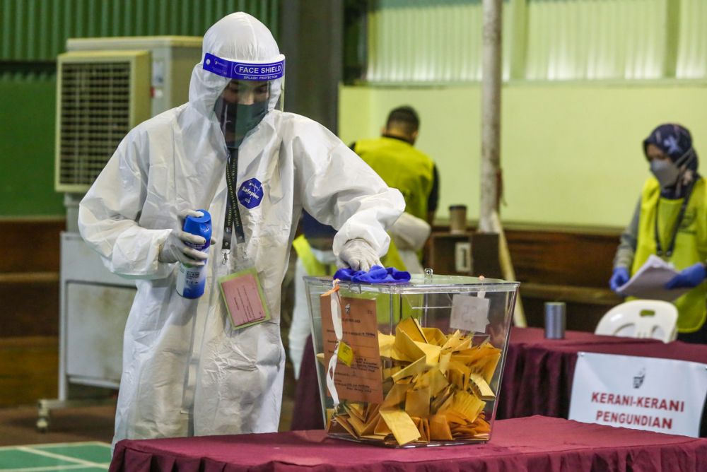 A Health worker sanitises a ballot box in Kuching during early voting in Kuching December 14, 2021. u00e2u20acu201d Picture by Yusof Mat Isa