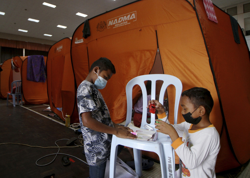 Flood victims Muhammad Nabil Irfan Safri, 10, (left) with his brother Fahmi Safri, 8, play with toys donated by Kaffah Kids at the Temporary Evacuation Centre ( PPS ) of Teluk Intan Town Hall, December 24, 2021. u00e2u20acu201d Bernama picnn