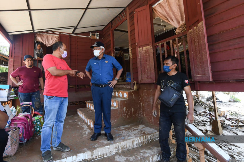 Home Minister Datuk Seri Hamzah Zainudin speaks to a flood victim in Hulu Langat, December 20, 2021. u00e2u20acu201d Picture from Twitter/Bernama 