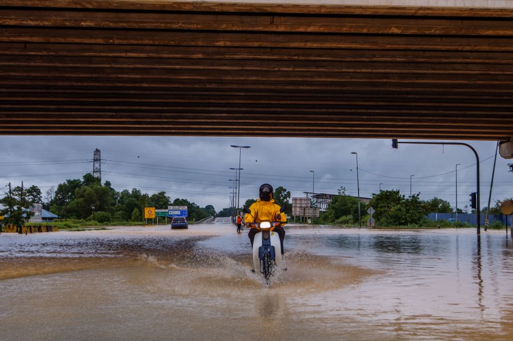 A motorcyclist rides through floodwaters on Jalan Labohan Dagang in Nilai December 18, 2021. u00e2u20acu2022 Picture by Shafwan Zaidon