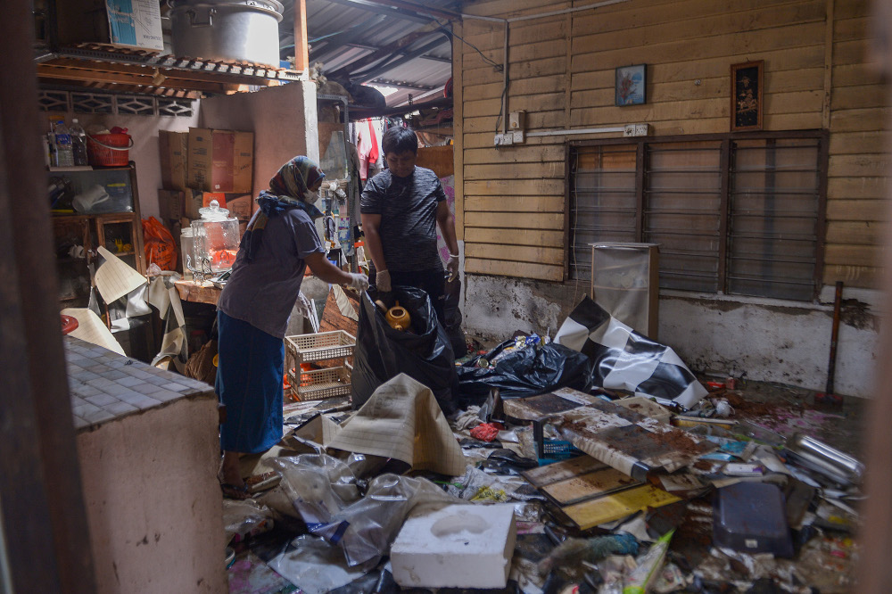 Flood victims clean their property after the massive flood in Puchong, December 22, 2021. u00e2u20acu201d   Picture by Miera Zulyana