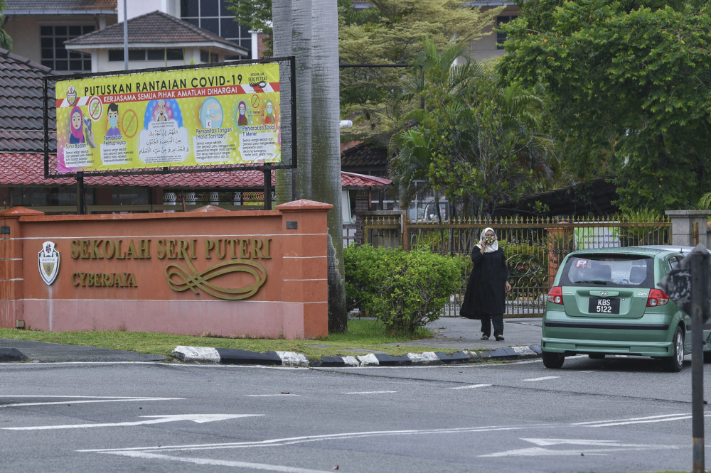 A woman is pictured speaking on the phone after she was not allowed entry to Sekolah Seri Puteri in Cyberjaya, December 2, 2021. u00e2u20acu201d Bernama pic 